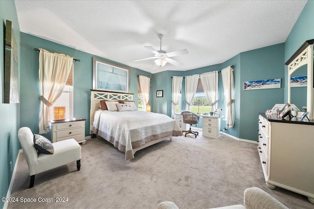 bedroom featuring ceiling fan, light colored carpet, and a textured ceiling