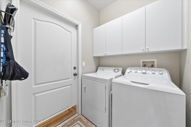 laundry area featuring washer and clothes dryer and cabinets