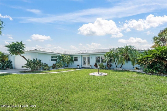 ranch-style home with french doors, a garage, and a front yard