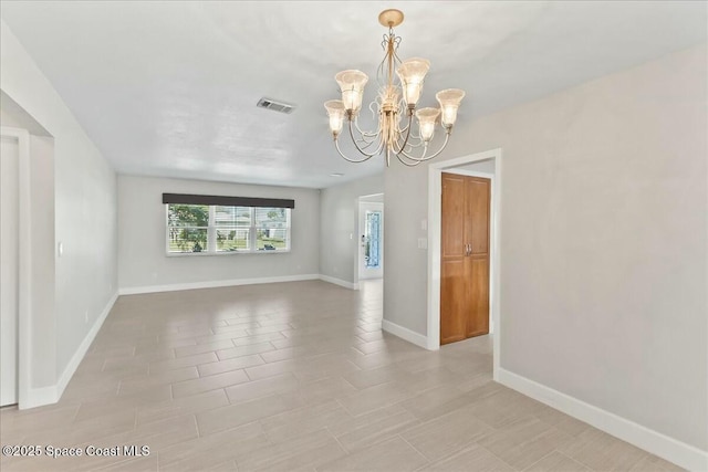 unfurnished room with an inviting chandelier and light tile patterned floors