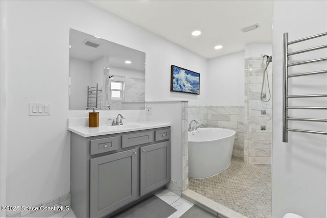 bathroom with vanity, radiator heating unit, plus walk in shower, and tile walls