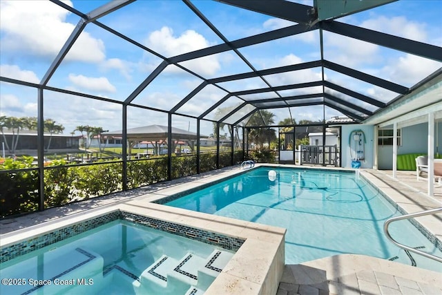 view of pool with a jacuzzi, a patio area, and a lanai