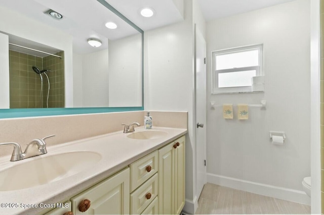 bathroom featuring vanity, toilet, and tiled shower