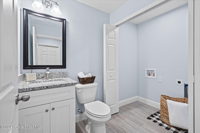 bathroom featuring hardwood / wood-style flooring, vanity, toilet, and a textured ceiling