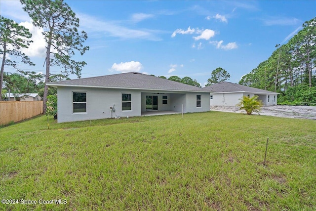 rear view of property featuring a lawn and a patio