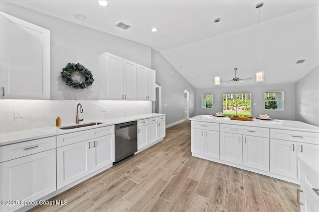 kitchen with dishwasher, light countertops, hanging light fixtures, and a sink