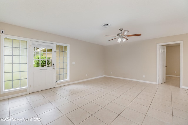 empty room with ceiling fan and light tile patterned floors