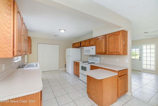 kitchen with white appliances, light tile patterned flooring, sink, and kitchen peninsula