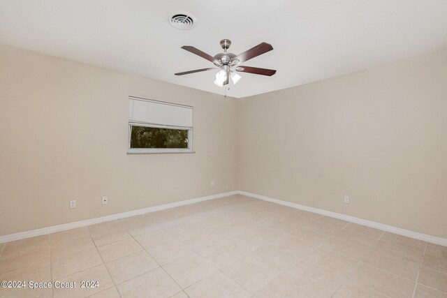 tiled empty room featuring ceiling fan