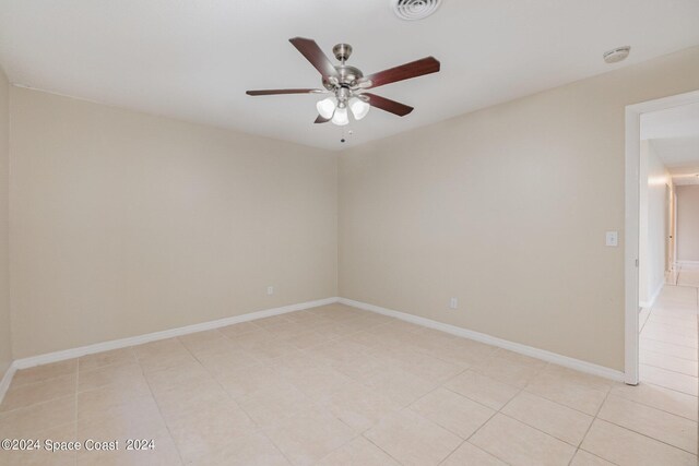 tiled spare room featuring ceiling fan