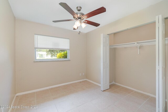 unfurnished bedroom featuring ceiling fan, a closet, and light tile patterned floors