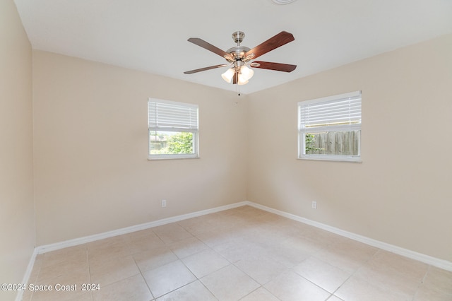 tiled spare room featuring ceiling fan