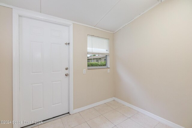 tiled foyer featuring vaulted ceiling