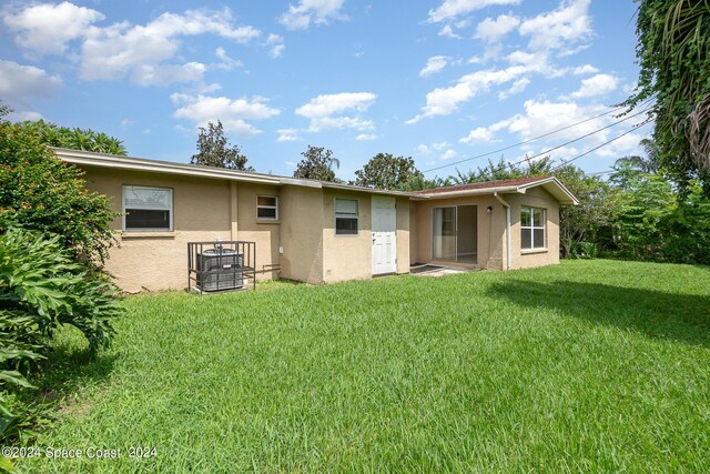 rear view of property with a lawn