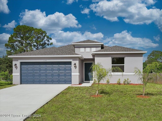 view of front of house featuring a garage and a front lawn