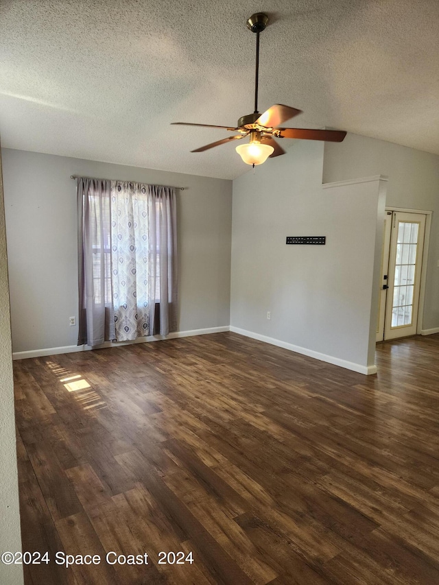 unfurnished room with a textured ceiling, dark wood-type flooring, ceiling fan, and a wealth of natural light