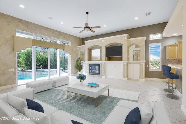 tiled living room with ceiling fan and plenty of natural light