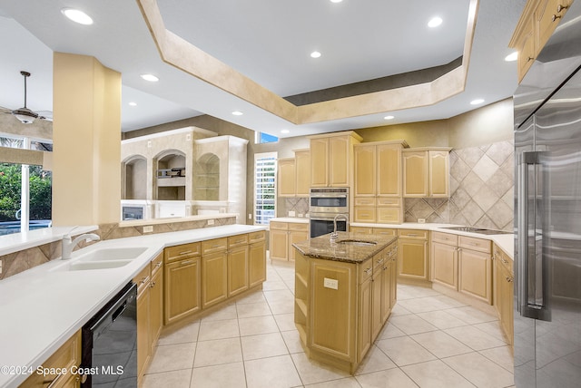 kitchen with a center island with sink, sink, black appliances, and a wealth of natural light