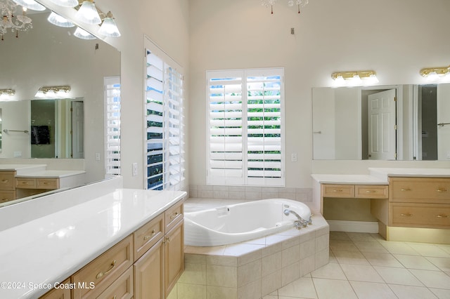 bathroom featuring vanity, tiled tub, and tile patterned flooring