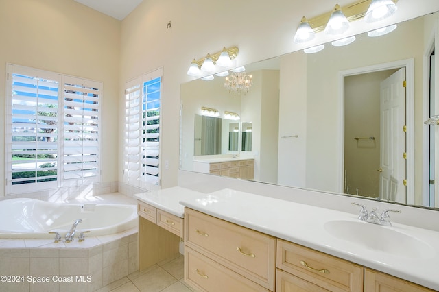 bathroom with vanity, tile patterned flooring, plenty of natural light, and tiled tub