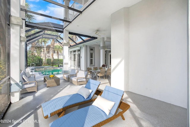 view of patio / terrace featuring ceiling fan, glass enclosure, and an outdoor hangout area