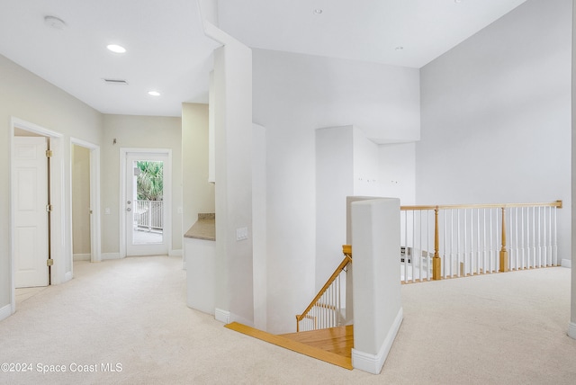 hallway with light colored carpet