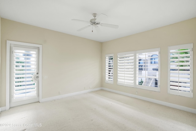 carpeted empty room featuring ceiling fan