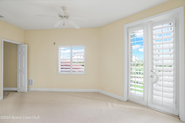 carpeted spare room featuring ceiling fan