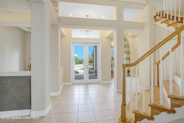 foyer featuring french doors, a chandelier, and light tile patterned floors