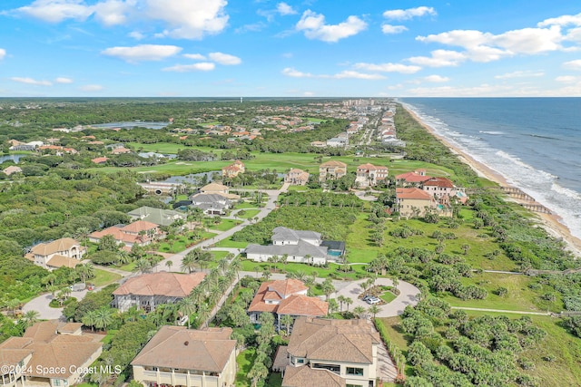 birds eye view of property with a water view and a beach view