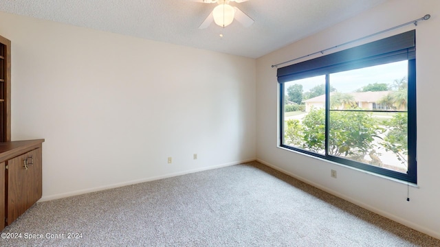 unfurnished room featuring ceiling fan, a textured ceiling, and carpet