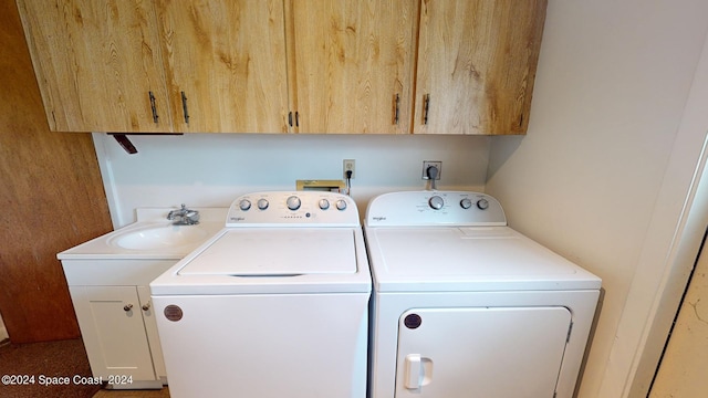 clothes washing area featuring cabinets, sink, and washing machine and clothes dryer