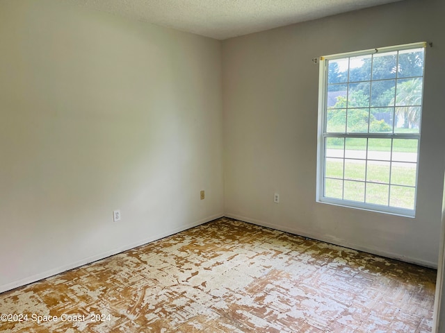 unfurnished room with a textured ceiling