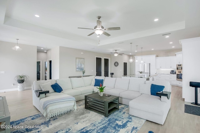 31 Seabridge Dr, Ormond Beach, FL 32176 - living room with a ceiling fan, a raised ceiling, light wood finished floors, and recessed lighting