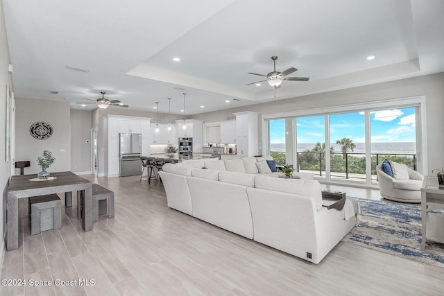 31 Seabridge Dr, Ormond Beach, FL 32176 - living room with ceiling fan, a raised ceiling, recessed lighting, and light wood-style flooring