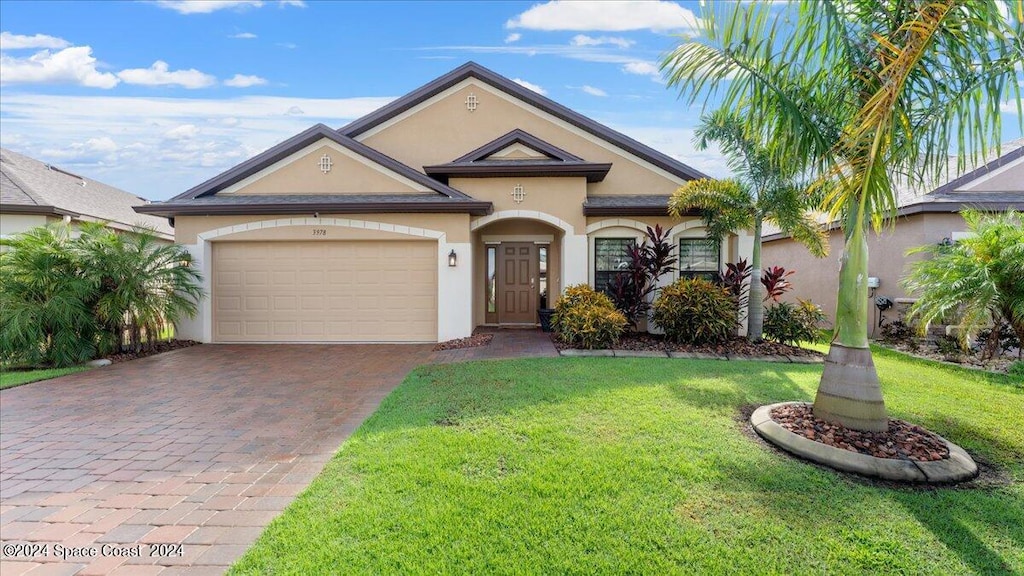 view of front of home with a front yard and a garage