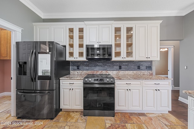 kitchen with light stone counters, white cabinets, stainless steel appliances, and decorative backsplash