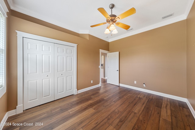 unfurnished bedroom featuring ceiling fan, a closet, crown molding, and dark wood-type flooring