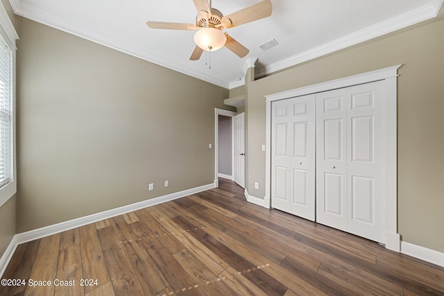 unfurnished bedroom with ceiling fan, a closet, dark hardwood / wood-style floors, and ornamental molding