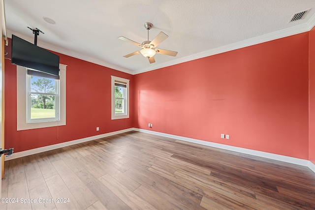 spare room with ceiling fan, a textured ceiling, ornamental molding, and wood-type flooring