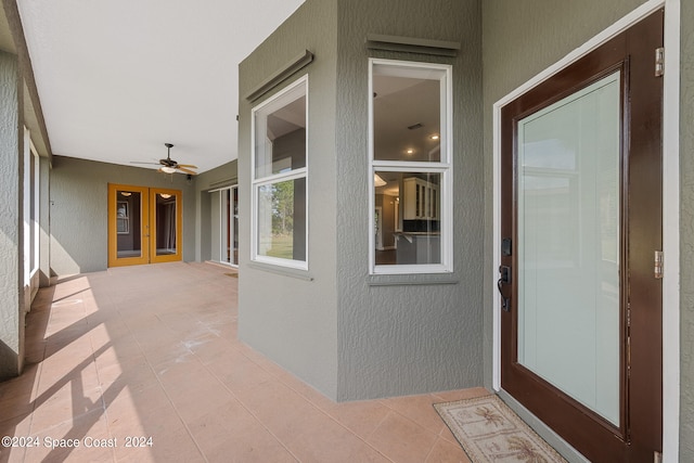 view of exterior entry featuring a patio and ceiling fan