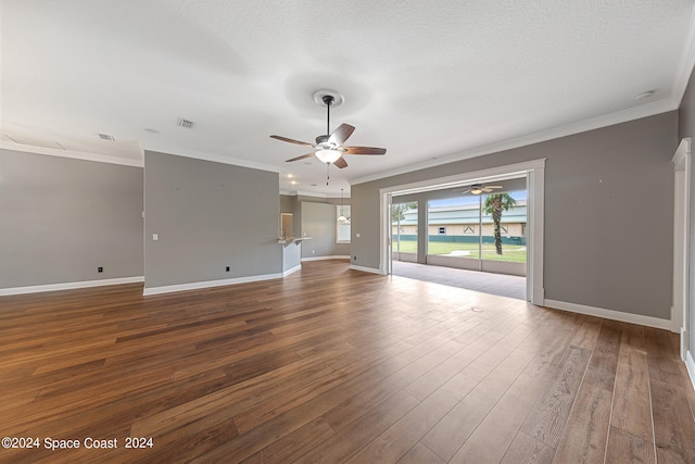 empty room with a textured ceiling, ornamental molding, ceiling fan, and hardwood / wood-style flooring