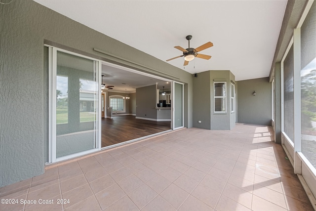 unfurnished sunroom featuring ceiling fan