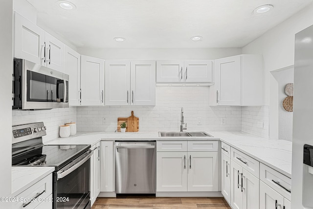 kitchen featuring stainless steel appliances, white cabinets, and sink