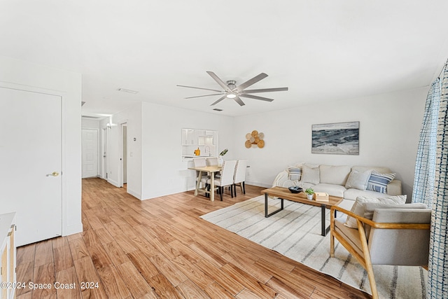 living room featuring ceiling fan and light hardwood / wood-style floors