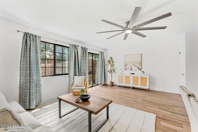 living room featuring ceiling fan, radiator, and light hardwood / wood-style floors