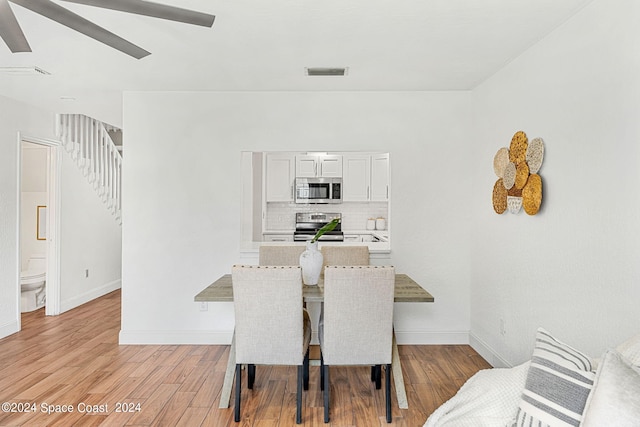 dining area with ceiling fan and light wood-type flooring