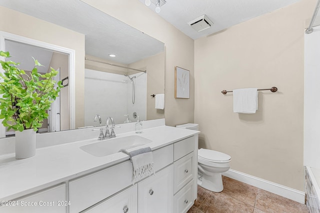 bathroom featuring tile patterned floors, a textured ceiling, vanity, and toilet