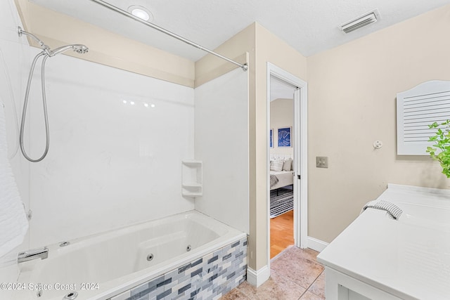 bathroom featuring a textured ceiling, tiled shower / bath combo, and tile patterned floors