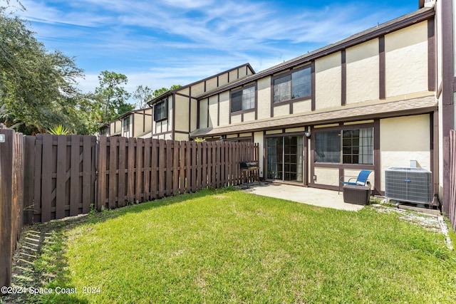 back of property featuring a patio, central AC, and a yard